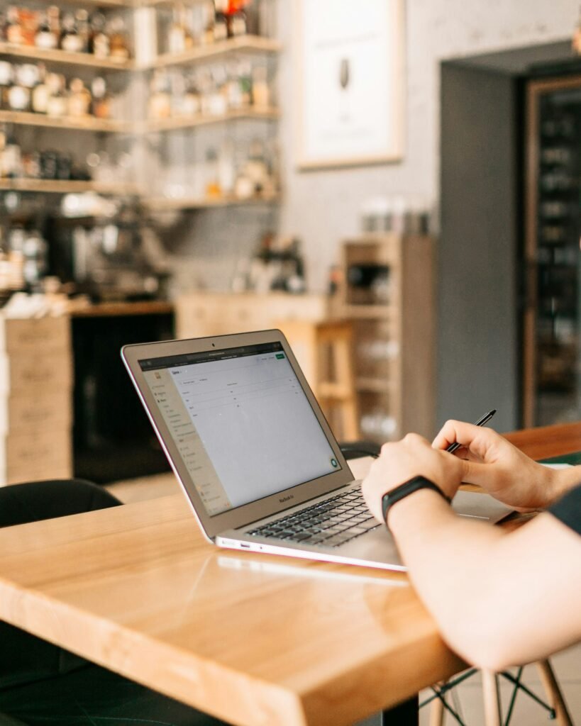 Restaurant manager reviewing performance and bookings on a laptop.